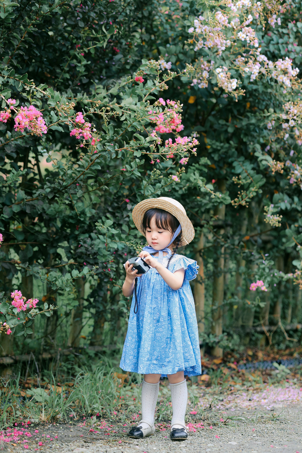 Girl wearing blue floral smocked dress outdoors front view