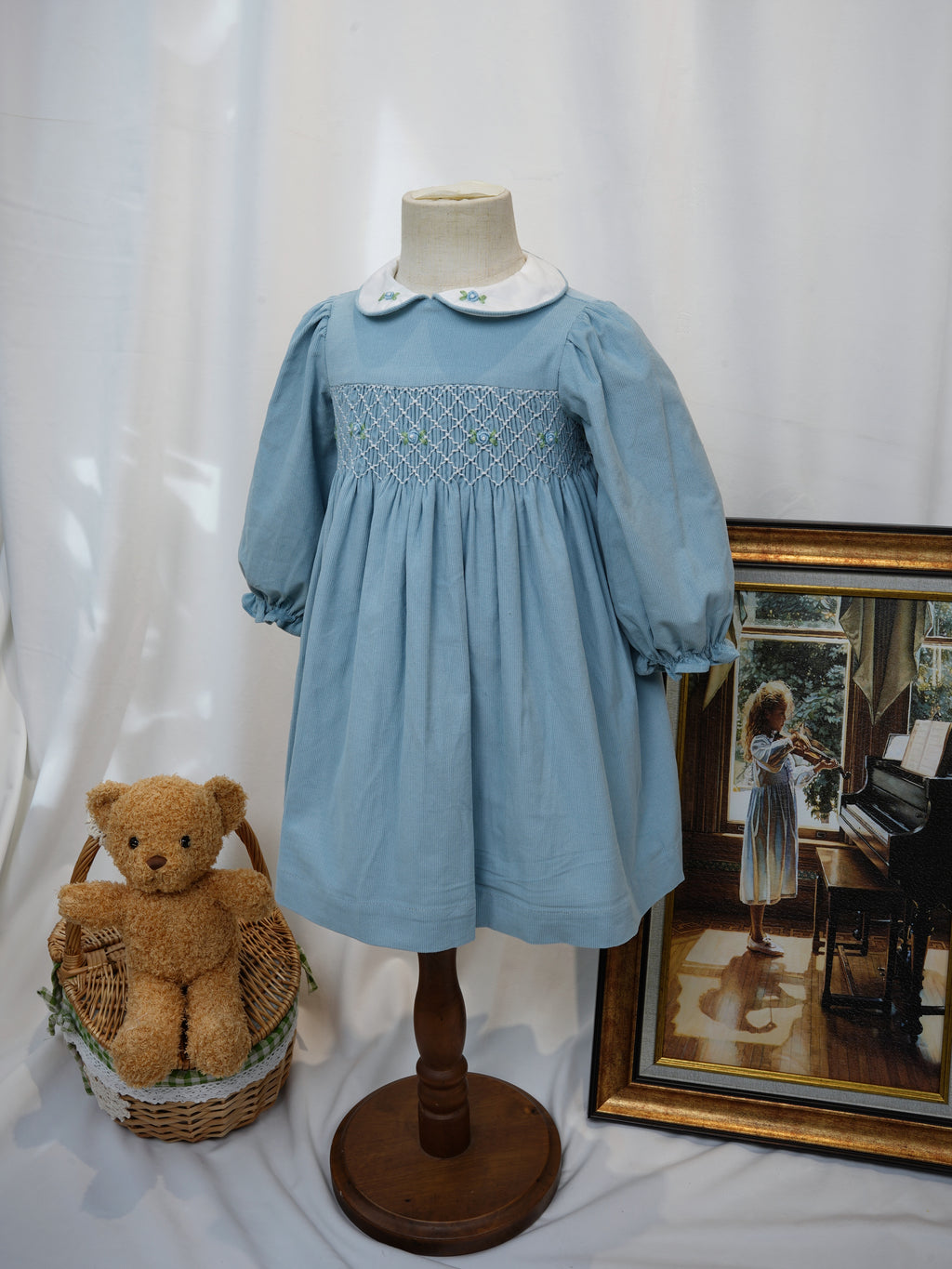 Angled front view of blue hand smocked long sleeve dress