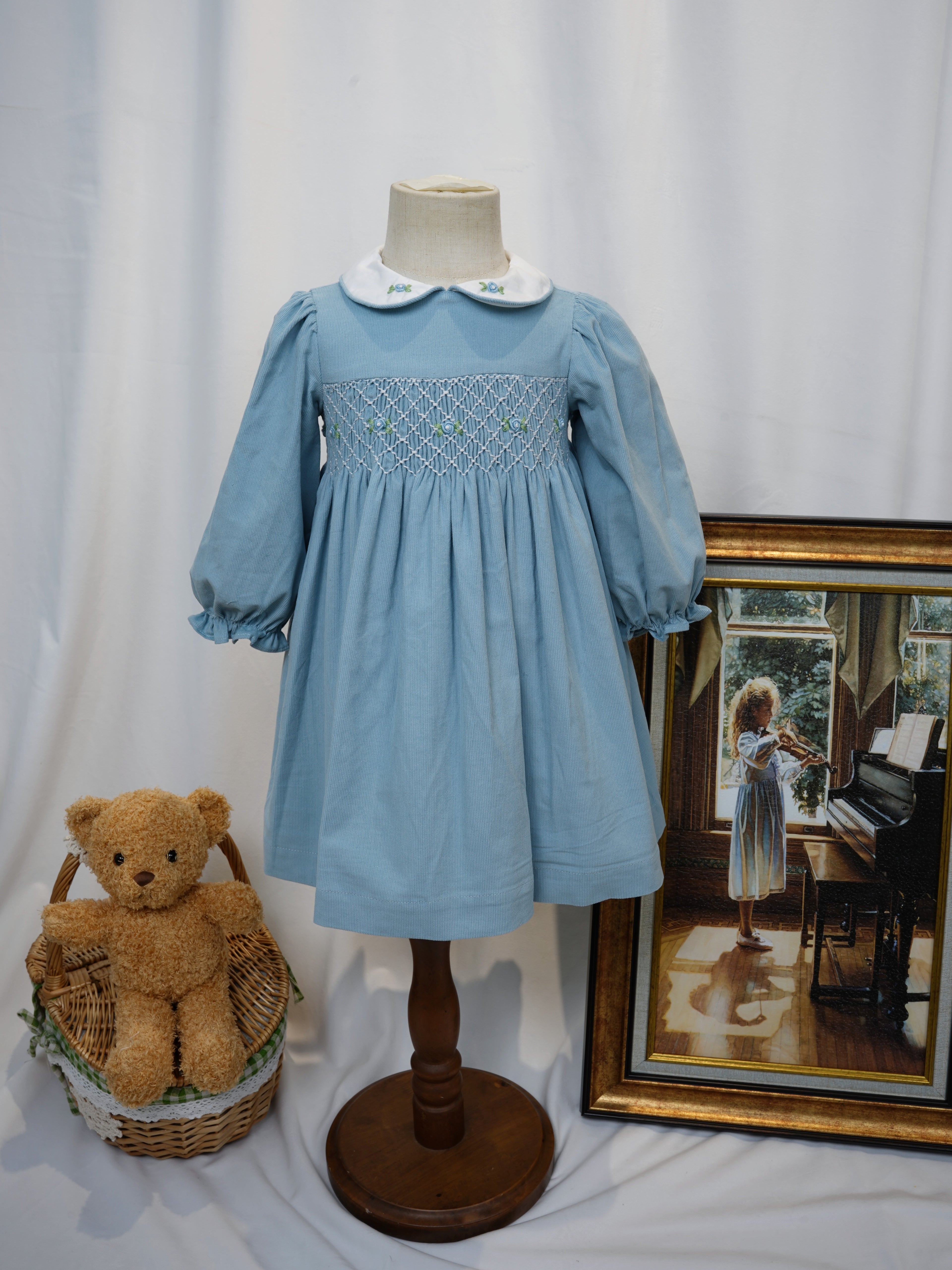 Front view of blue hand smocked dress with Peter Pan collar