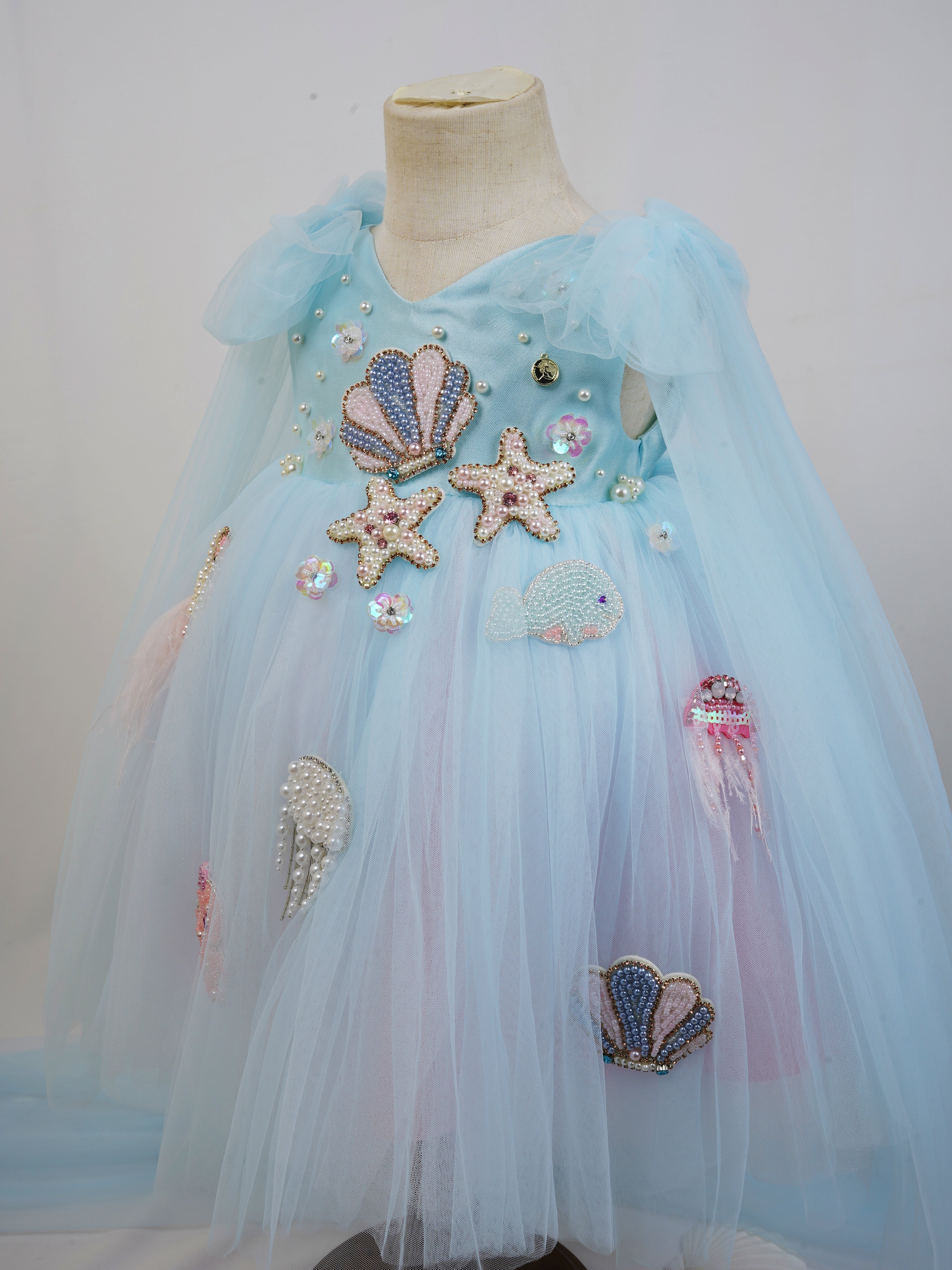 angled view showing shoulder tie cape and layered tulle skirt