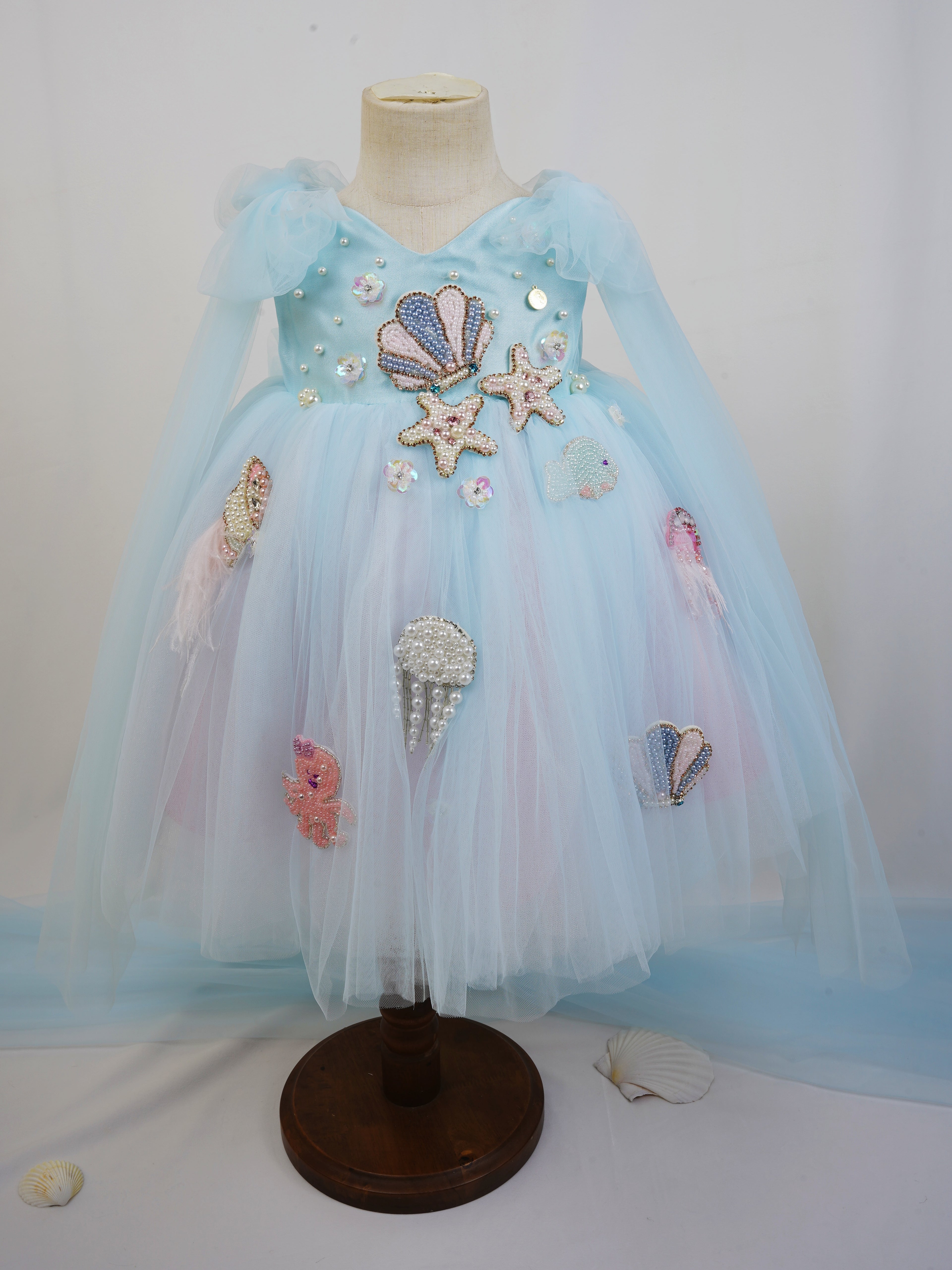 front view of blue ocean tulle dress with pearl shells and starfish for toddler