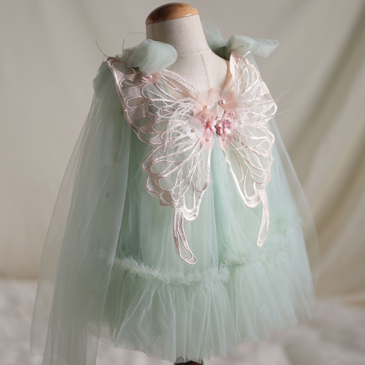 Back view showing butterfly wings detail on mint tulle dress