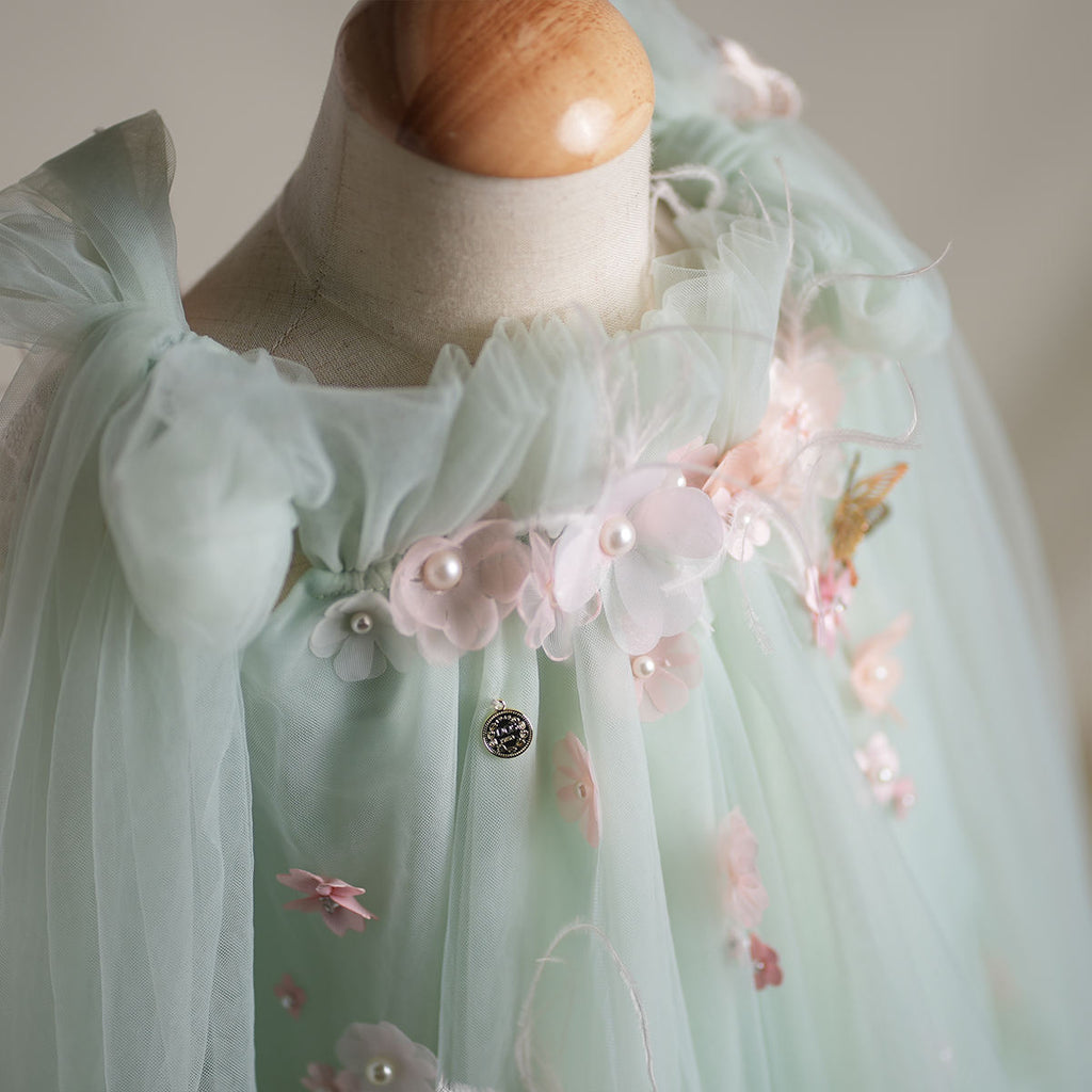 Close-up of 3D flowers with pearl centers on mint bodice