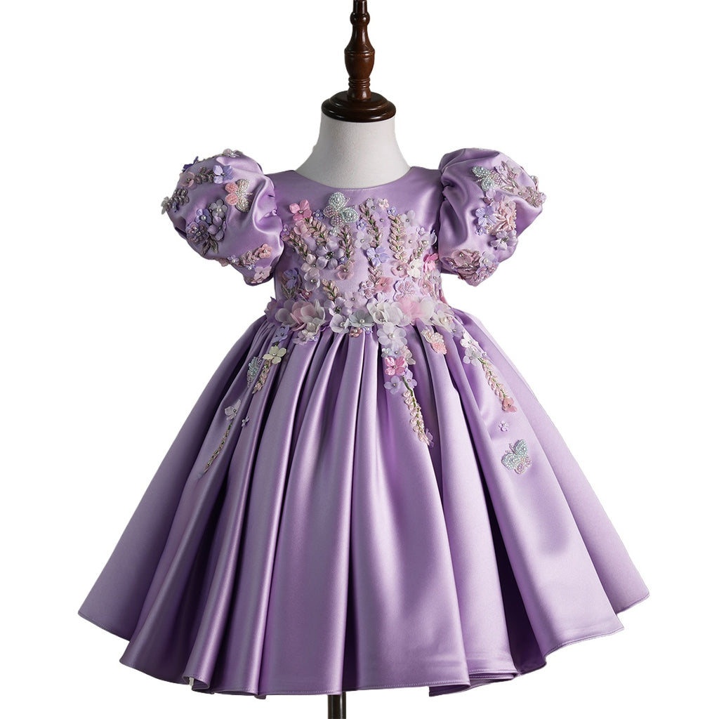 Front view of a lavender luxury handcrafted baby girl dress with puff sleeves, floral appliqués, and satin finish, perfect for birthdays, weddings, and special occasions.