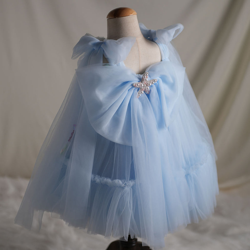 Back view showing detachable oversized bow and cape-like tulle