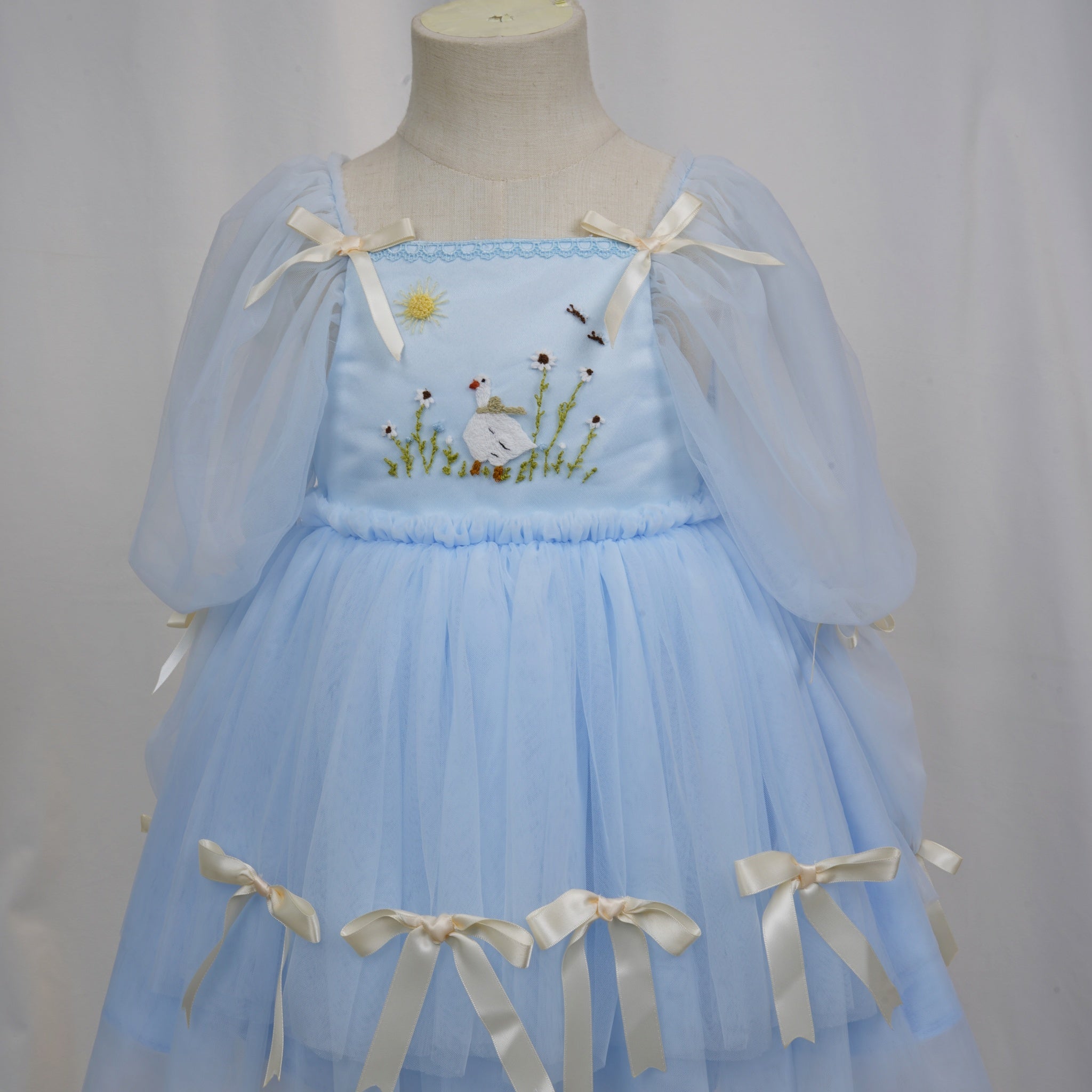 Full front view of layered light blue tulle skirt with bows