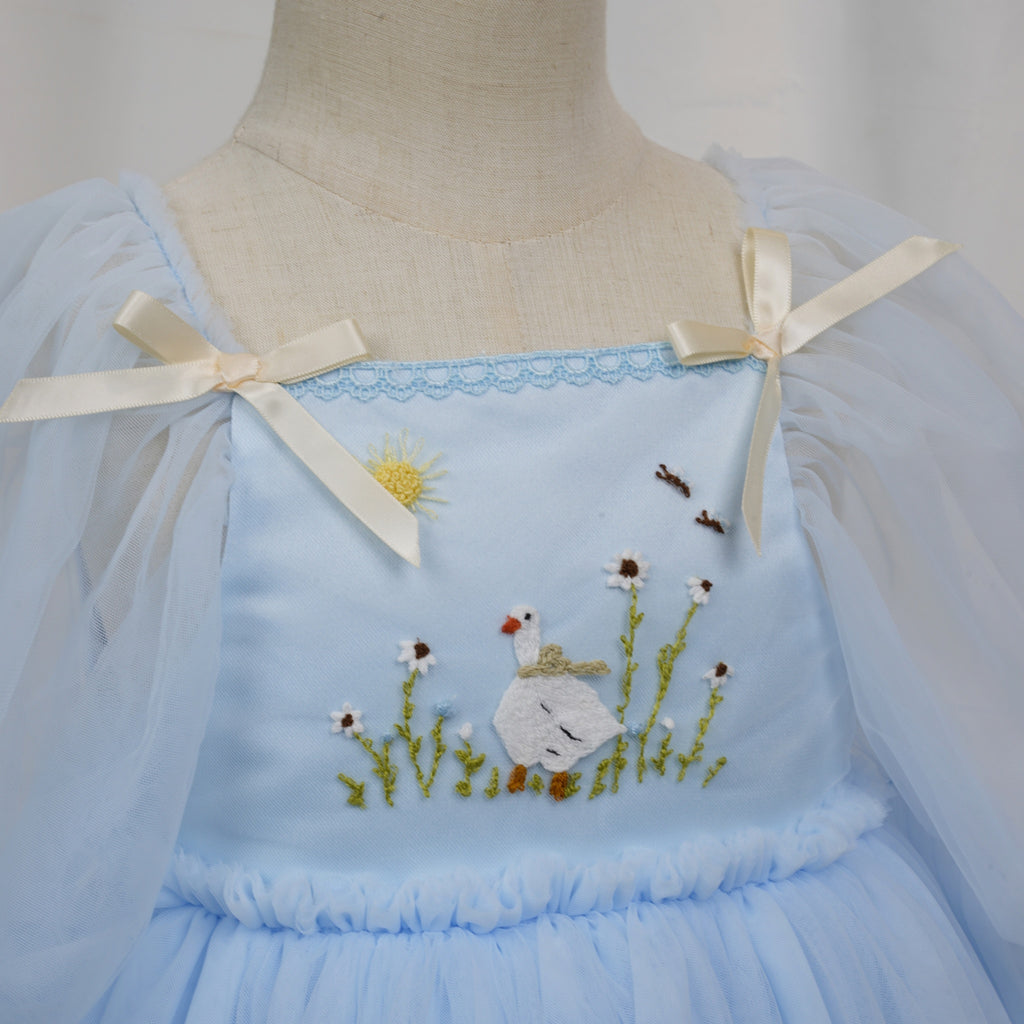 Close-up of goose and daisy embroidery with sun on satin bodice