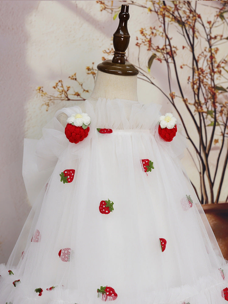 Close-up of strawberry appliqués and ruffle neckline on white tulle dress